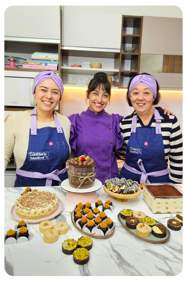 Natalia com alunas em curso presencial, com doces saudáveis sobre a bancada
